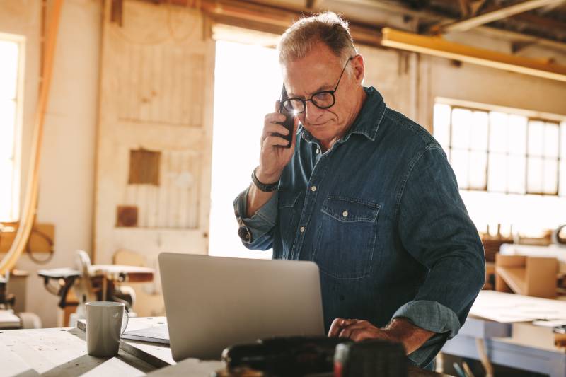 Business owner on phone reviewing invoices