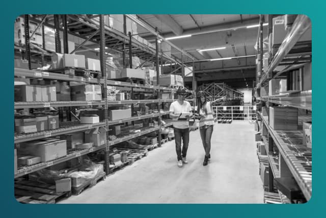 Two warehouse workers walking in distribution storage area